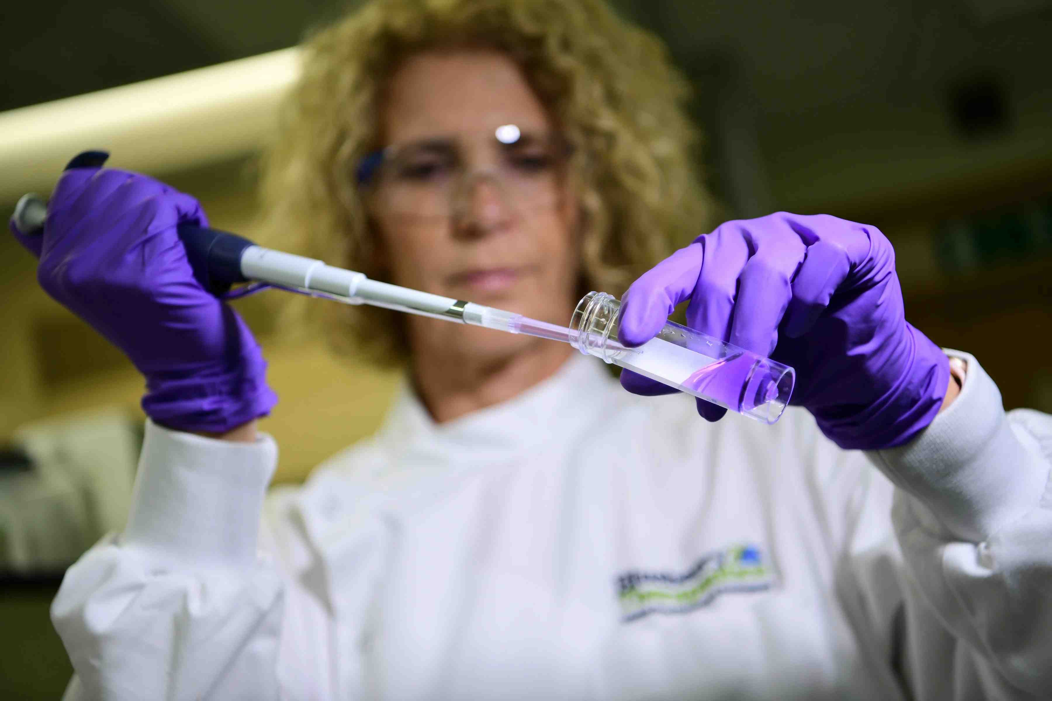 Woman with pipette in biotech company