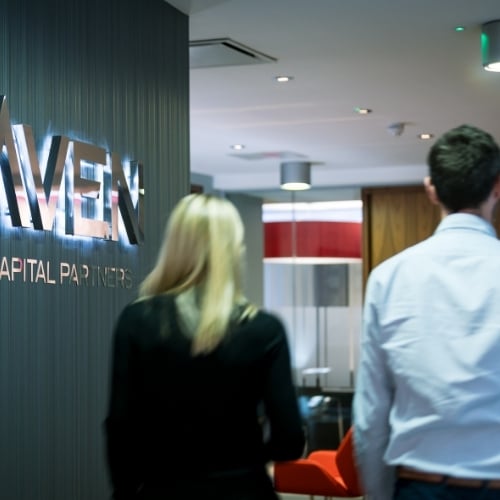 Maven staff walking past sign